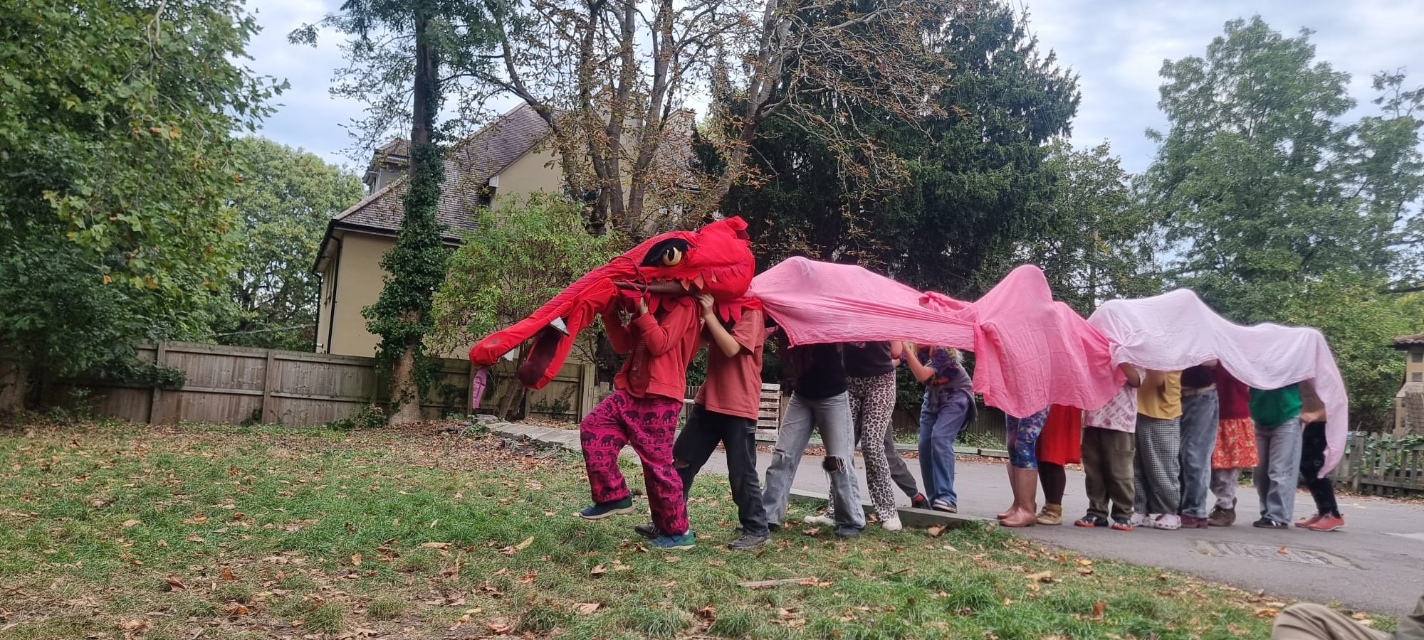 Children performing a dragon procession outdoors during a Michaelmas celebration